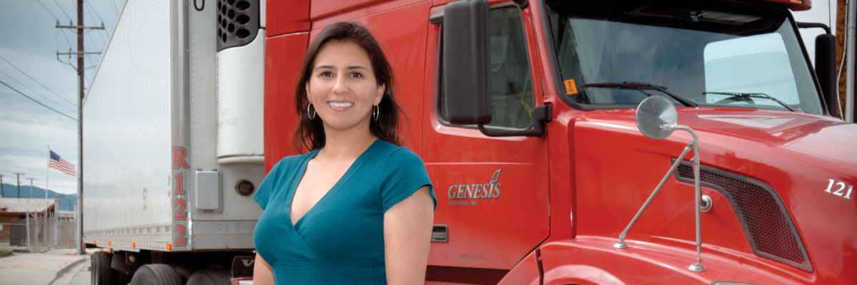 Lina Gomez from Genesis Freightlines, Inc. in front of the truck smiling.