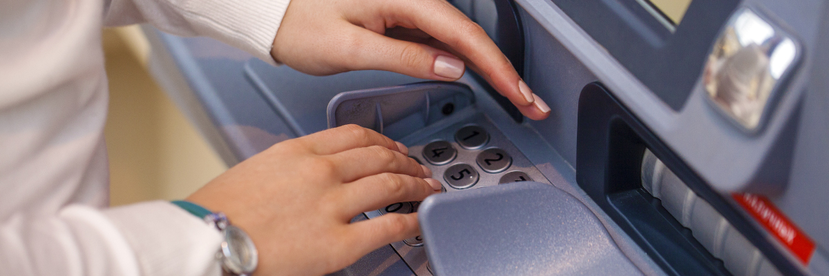 A woman cover her pin number at the ATM/Debit machine